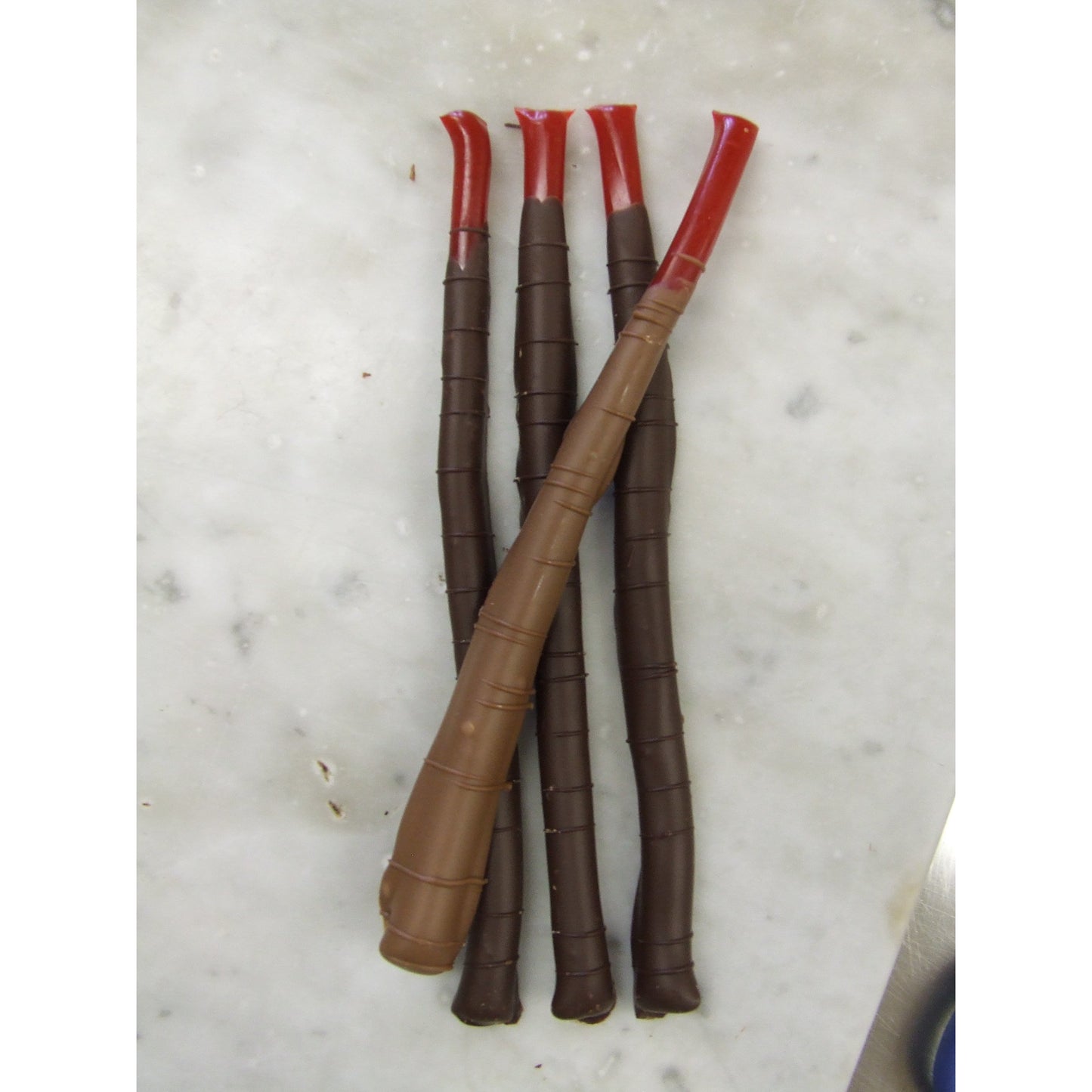 Package of 4 6 inch red licorice sticks dipped in hand made Belgian chocolate.  Cello wrapped.  Available in dark or milk chocolate.